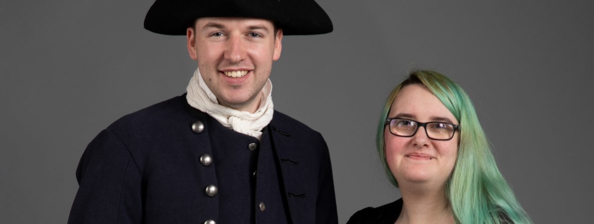 Rowan on the left and a man on the right, who is wearing a costume Rowan made. They are both looking at the camera and smiling.