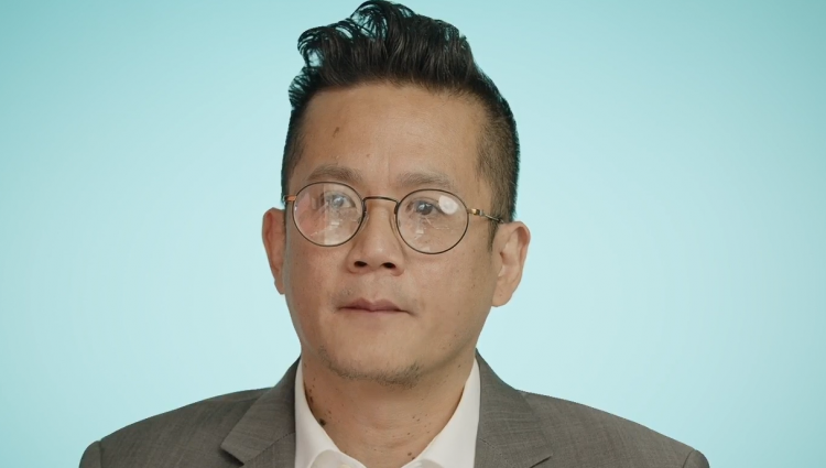 Darren Tan. A man wearing smart casual office attire with glasses.
