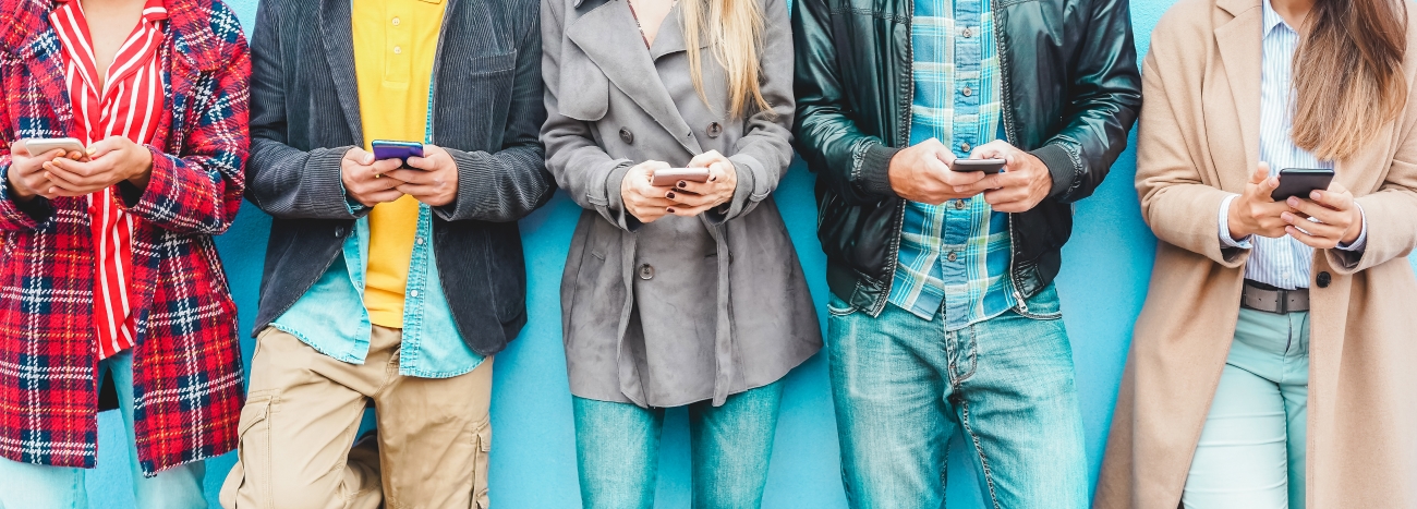 A group of students standing in a row, holding a smartphone, ready to use navigation apps to find their way.