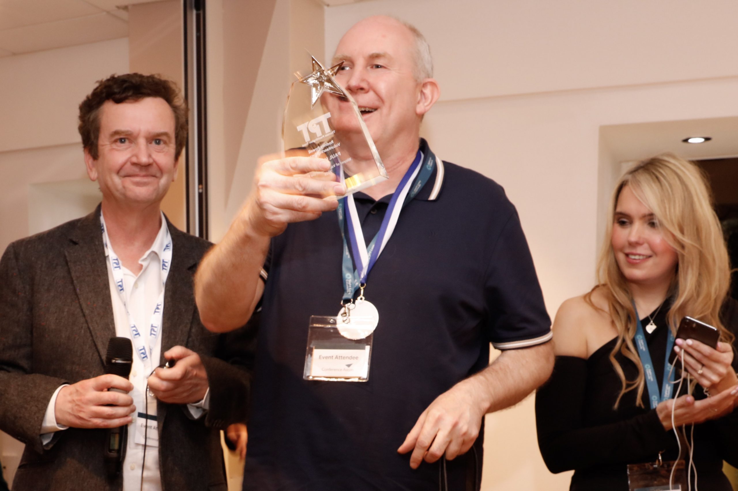 TPT CEO Charles Colquhoun (left) with Claire Sisk (right). In the centre SLC volunteer Paul is holding his award. He is smiling.