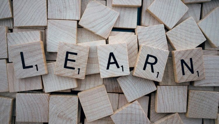 A series of wooden letter tiles that spell out the word learn in capitals.