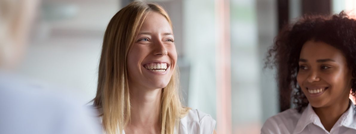 Two young businesswomen during a meeting smiling