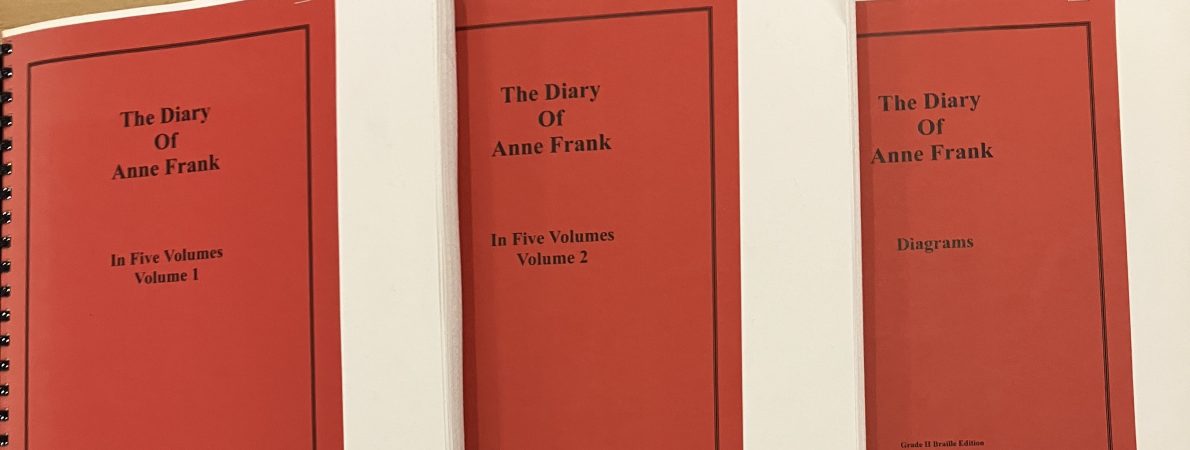 Braille versions of Anne Franke's diary are laid out across a table.