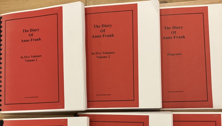 Braille versions of Anne Franke's diary are laid out across a table.