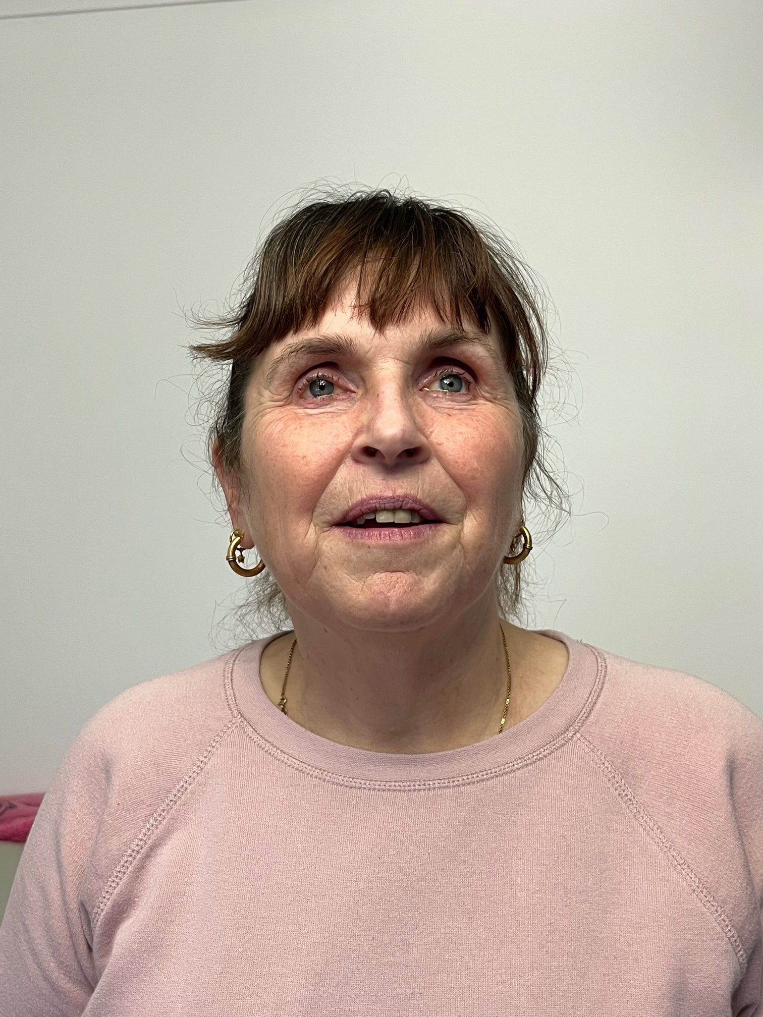 Headshot of Sussex Sight Loss Council member, Alison. She has dark hair, pulled back into a ponytail. She is wearing a light pink top and is smiling at the camera.