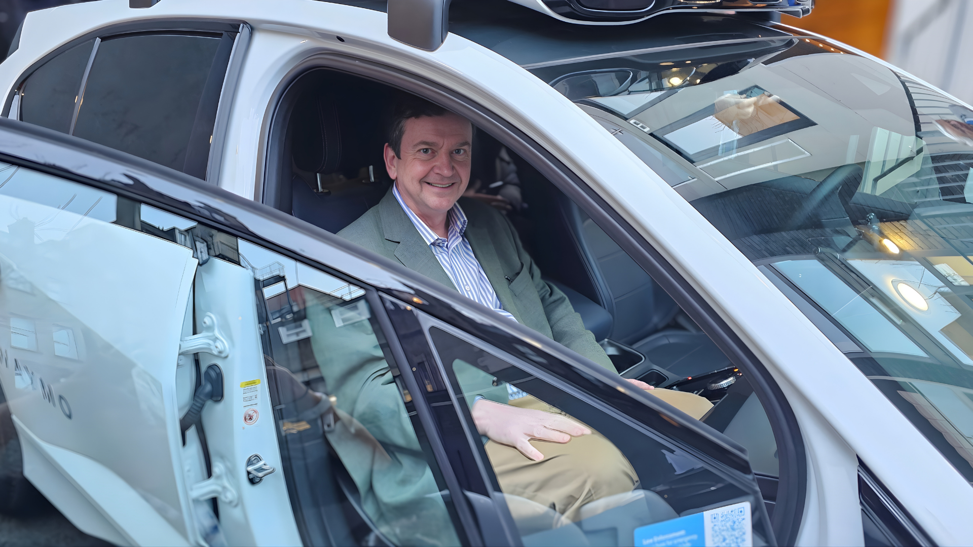 Close up of Charles sitting inside the Waymo car