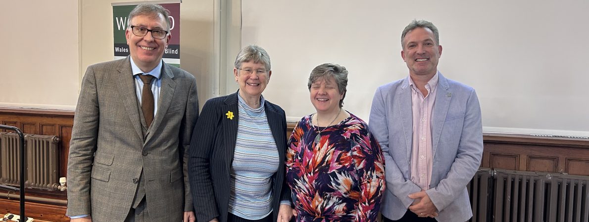 From left to right: Owen Williams, Director of Wales Council of the Blind, Jane Hutt MS, Cabinet Secretary for Social Justice, Anita Davies, Engagement Manager for Wales, and Martin Symcox, Head of Partnerships at Thomas Pocklington Trust. They are stood together in a line, smiling at the camera, during the launch event.