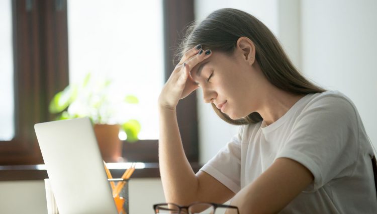 A picture of a young woman despairing in front of a laptop | links to article: What to Do If Things Go Wrong at University