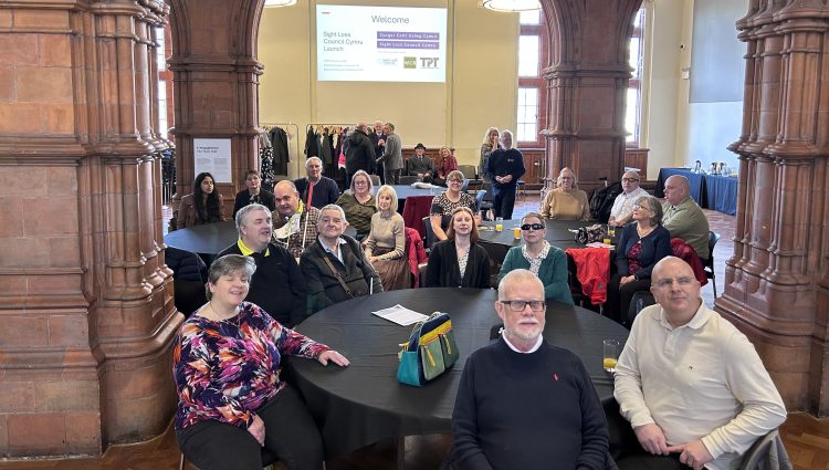 Wales Sight Loss Council members seated around tables in a large hall during the launch event.