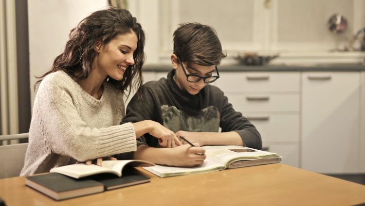 A woman and boy sit at a kitchen table doing homework | links to article: How Do I Raise a Concern About My Child’s EHCP?