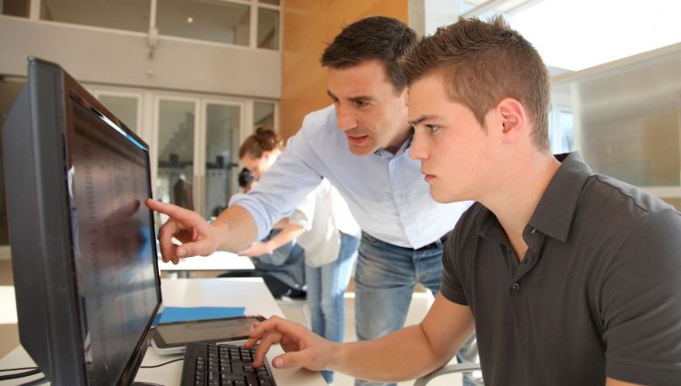 A man showing a younger man something on a computer's screen | links to article: How to Navigate Work Placements at University