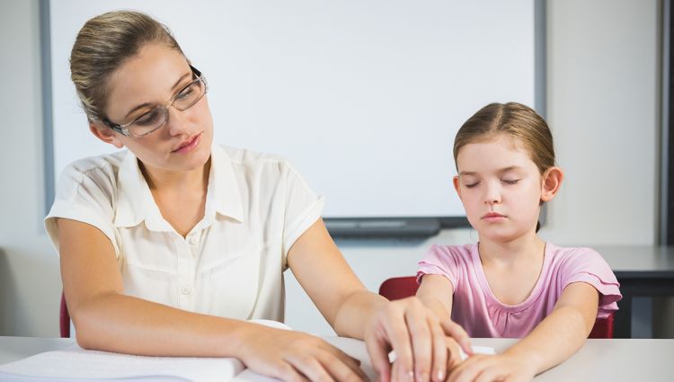 Woman reading with braille with a young girl | links to article: How Should Your Child Be Supported at School or College?