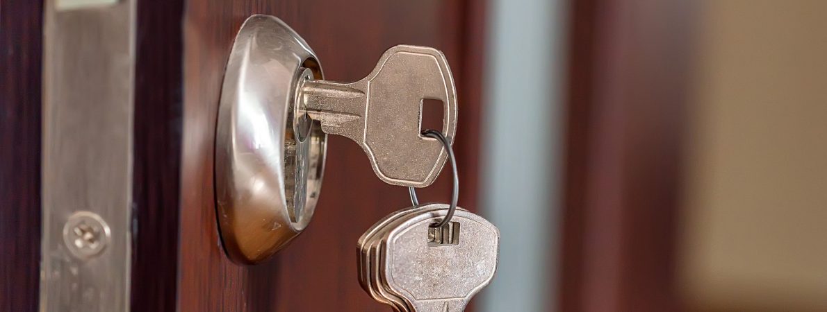 Close up image of keys in door of a house