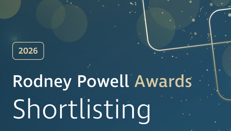 Graphic banner with a dark blue gradient background featuring soft, translucent circular shapes and scattered gold dots. On the left, a gold‑outlined rounded rectangle contains the text “2026.” Large white and gold text reads “Rodney Powell Awards,” with “Shortlisting” displayed prominently below in white. Decorative curved gold lines sweep across the right side, with a subtle glowing effect near the lower right corner, adding a celebratory, polished feel.