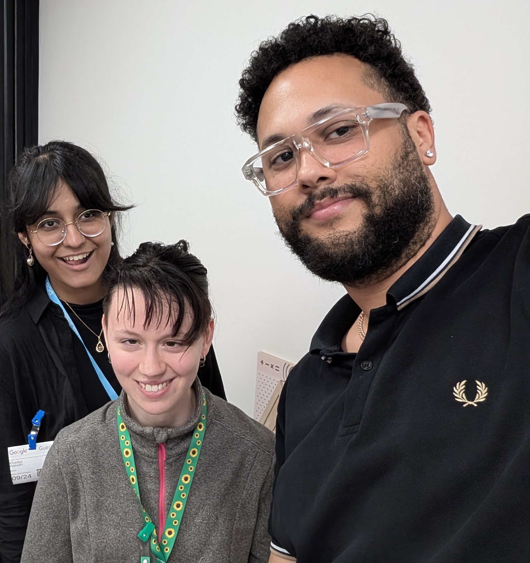 Selfie photo of Khadija and Faith, Student Voices members, taken by XX. All are looking at the camera, smiling.