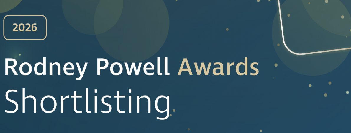 Graphic banner with a dark blue gradient background featuring soft, translucent circular shapes and scattered gold dots. On the left, a gold‑outlined rounded rectangle contains the text “2026.” Large white and gold text reads “Rodney Powell Awards,” with “Shortlisting” displayed prominently below in white. Decorative curved gold lines sweep across the right side, with a subtle glowing effect near the lower right corner, adding a celebratory, polished feel.