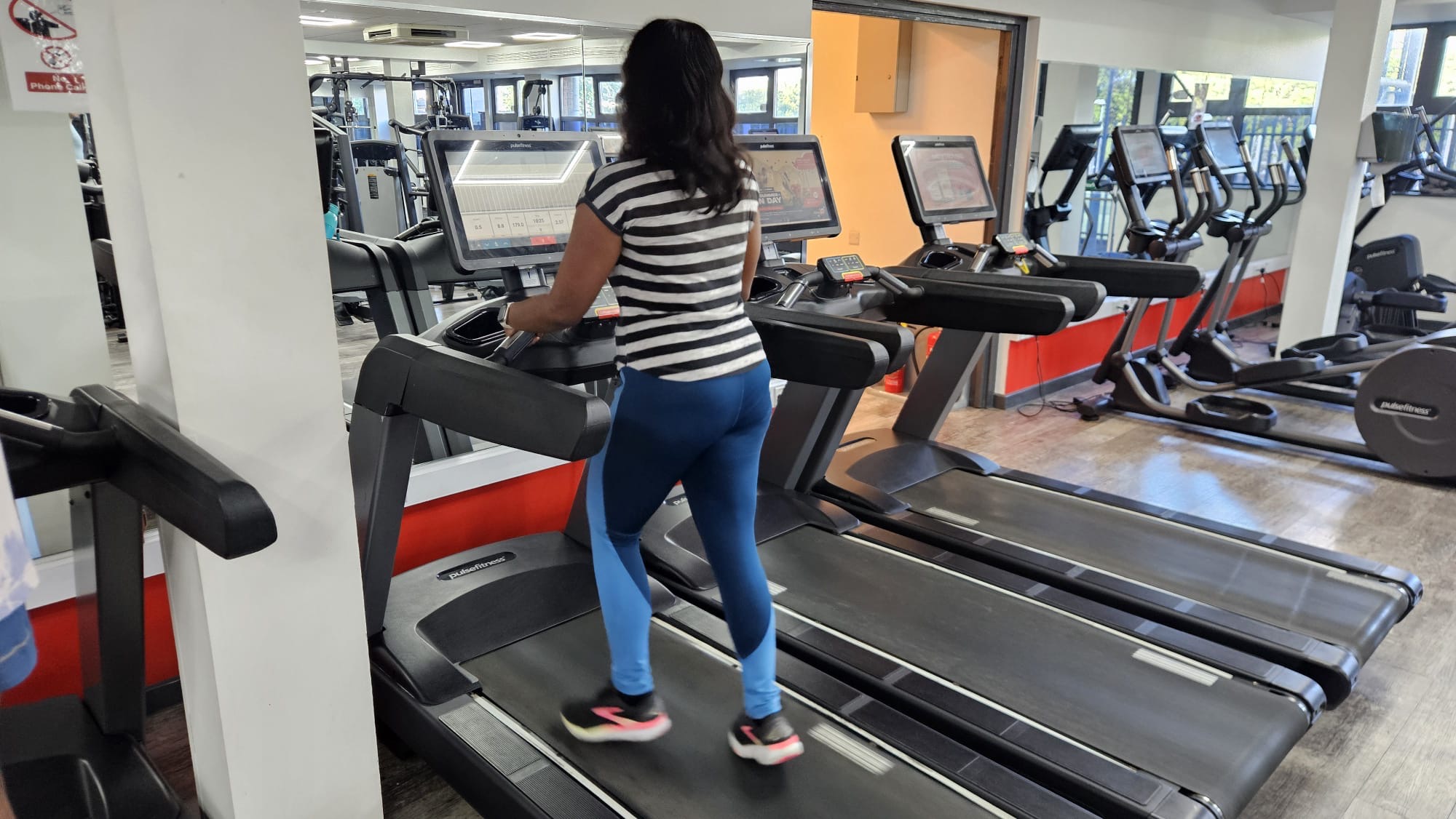 Deepika is running on a treadmill practising at a gym.