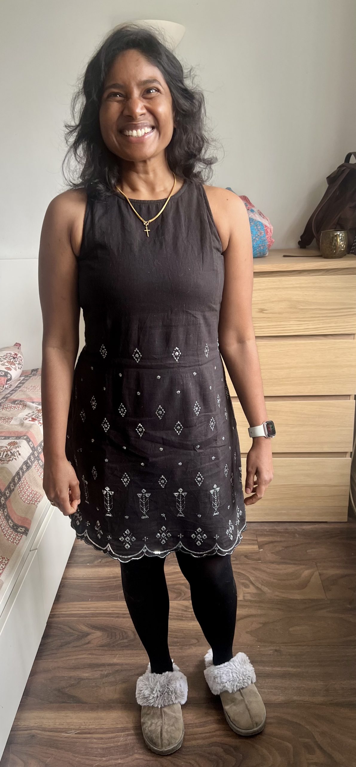 Deepika stood indoors looking very happy and smiling at the camera. She is wearing a brown dress.