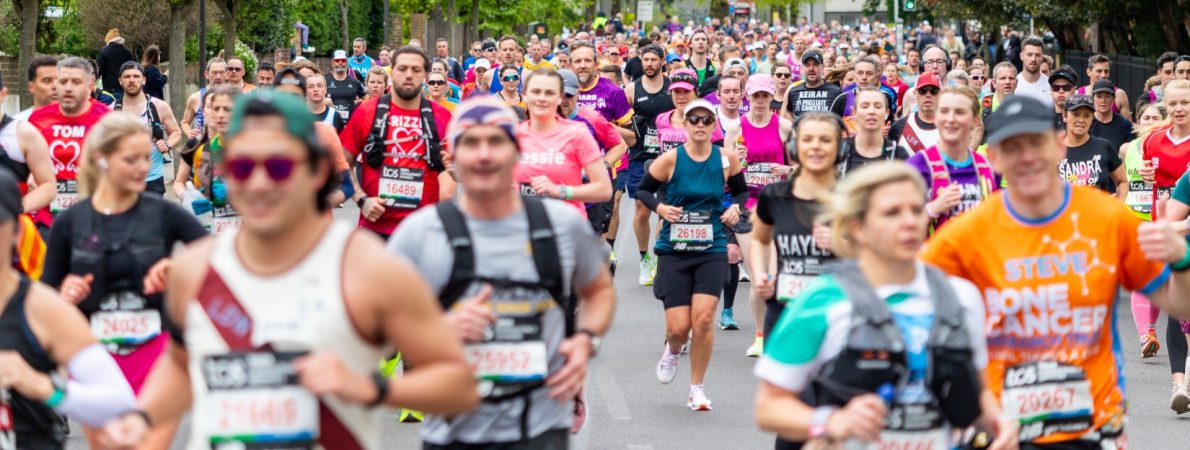 Hundreds of runners running down a London road for the 2026 marathon.