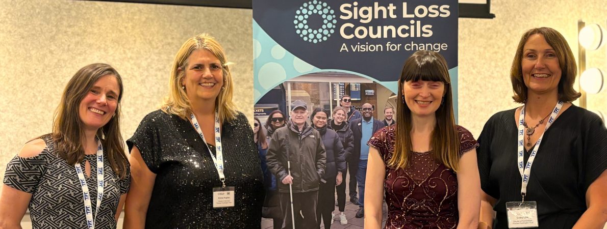 Louise Upton-James, Director of Resources, Emma Hughes, Director of Services, Fern Lulham, Rodney Powell Award host, and Cathy Lowe, Director of Partnerships, stand beside a Sight Loss Councils at the Rodney Powell Awards.