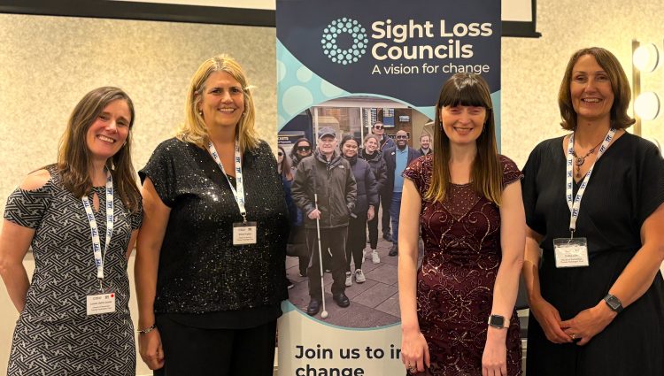 Louise Upton-James, Director of Resources, Emma Hughes, Director of Services, Fern Lulham, Rodney Powell Award host, and Cathy Lowe, Director of Partnerships, stand beside a Sight Loss Councils at the Rodney Powell Awards. | links to article: Rodney Powell Awards 2026: Celebrating the volunteers creating change