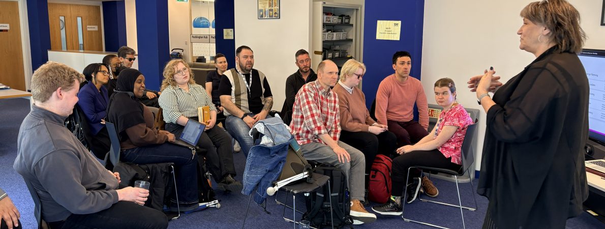 A group of people engaged with the session trainer in an office setting