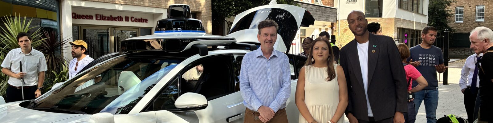 TPT Chief Executive Charles Colquhoun, TPT Policy and Campaigns Manager Bhavini Makwana and Waymo representative Nathan Ashley standing in front of the Waymo car.